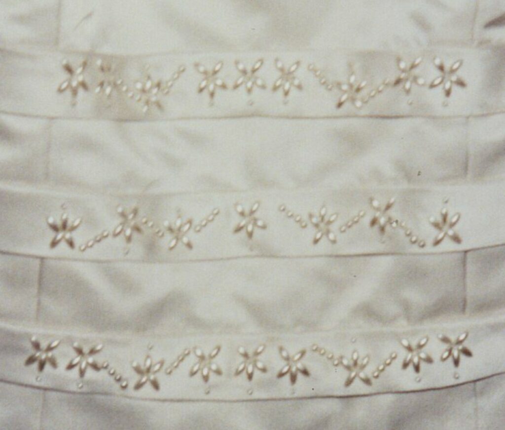 Hand beaded detail on a wedding dress based on a design in my embroidery portfolio.  Commissions made to order.